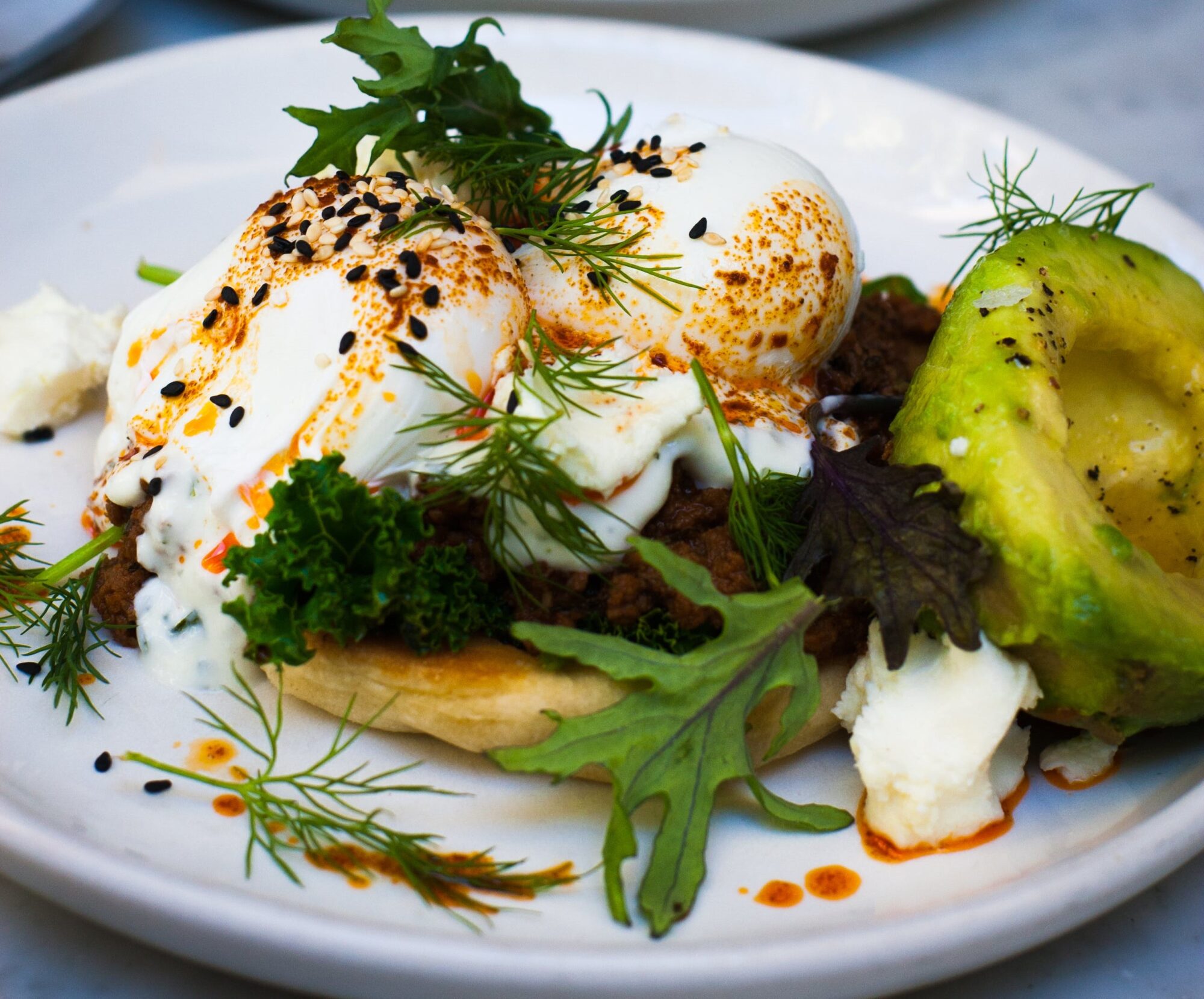 Ensalada de burrata sobre pan y vinagreta de pesto rojo